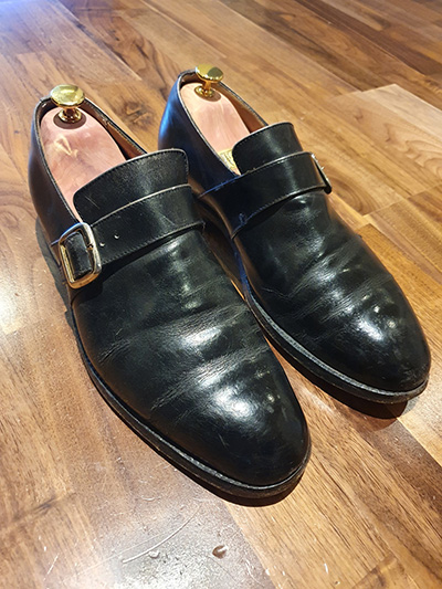 Pair of cracked, black Ducker monk shoes